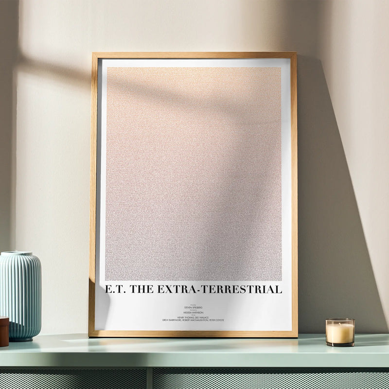 A framed E.T. the Extra-Terrestrial movie script poster displayed in a simple modern interior.