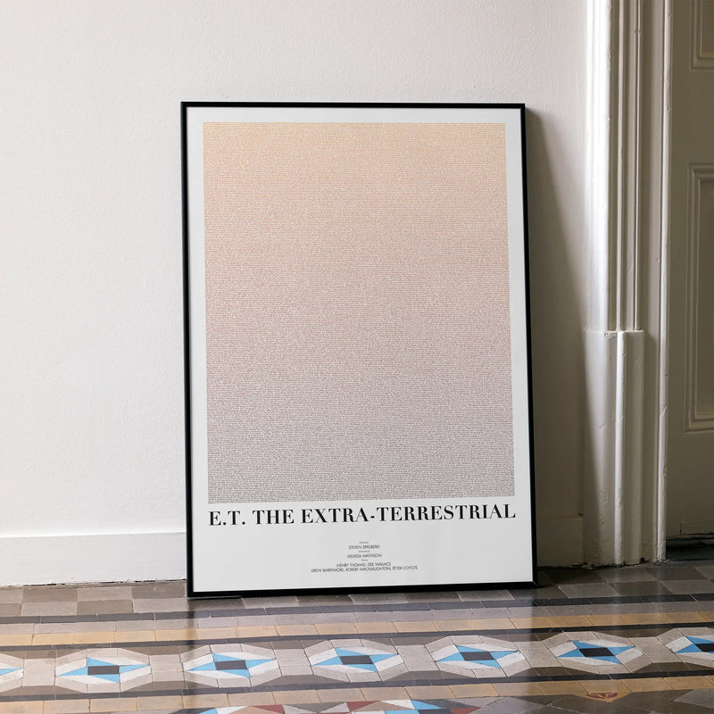 A framed E.T. the Extra-Terrestrial movie script poster leaning against a wall in a minimalist interior.
