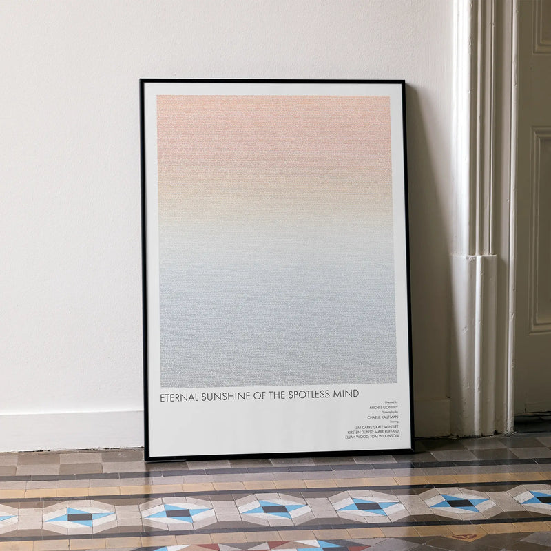 A framed Eternal Sunshine of the Spotless Mind movie script poster leaning against a wall in a minimalist interior.
