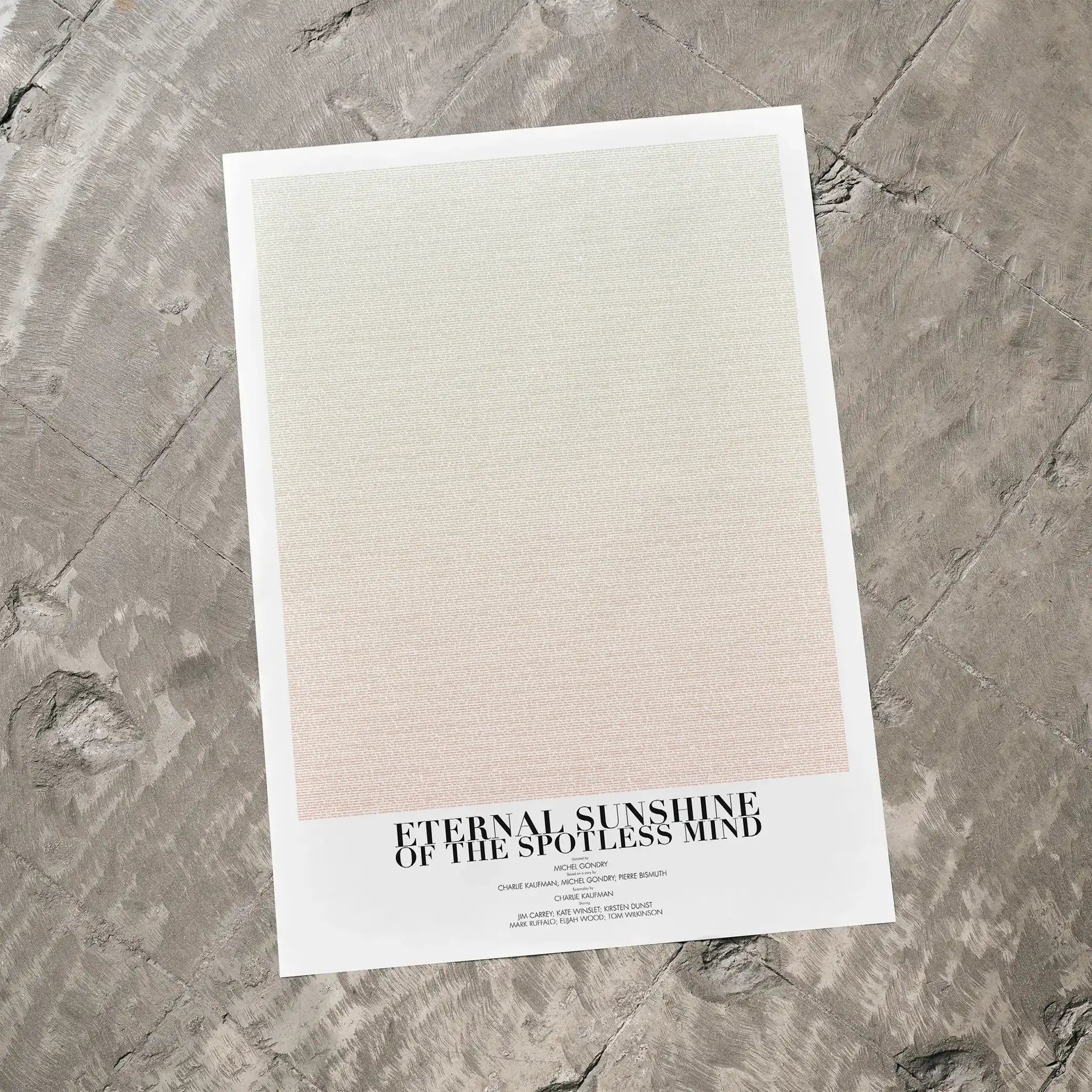 A Eternal Sunshine of the Spotless Mind movie script poster laid flat on a textured floor surface.