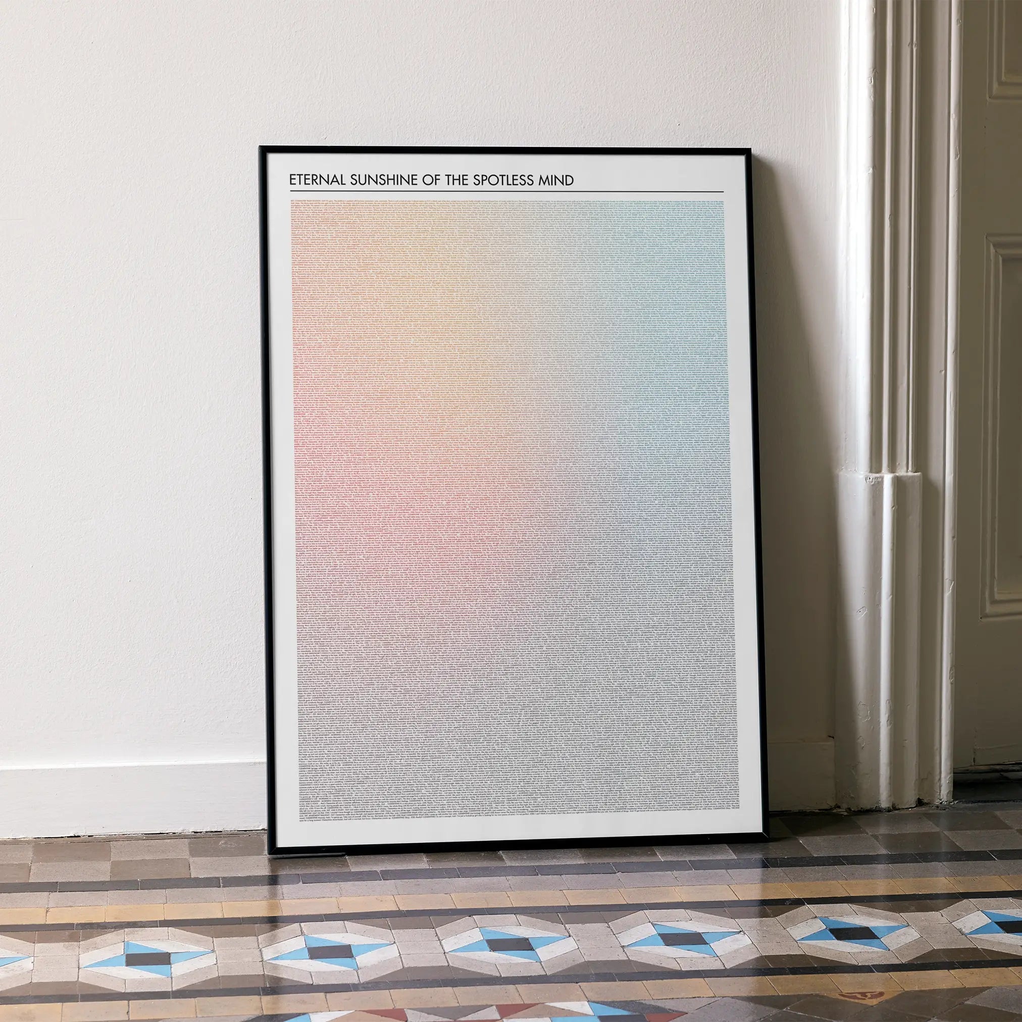 A framed Eternal Sunshine of the Spotless Mind movie script poster leaning against a wall in a minimalist interior.