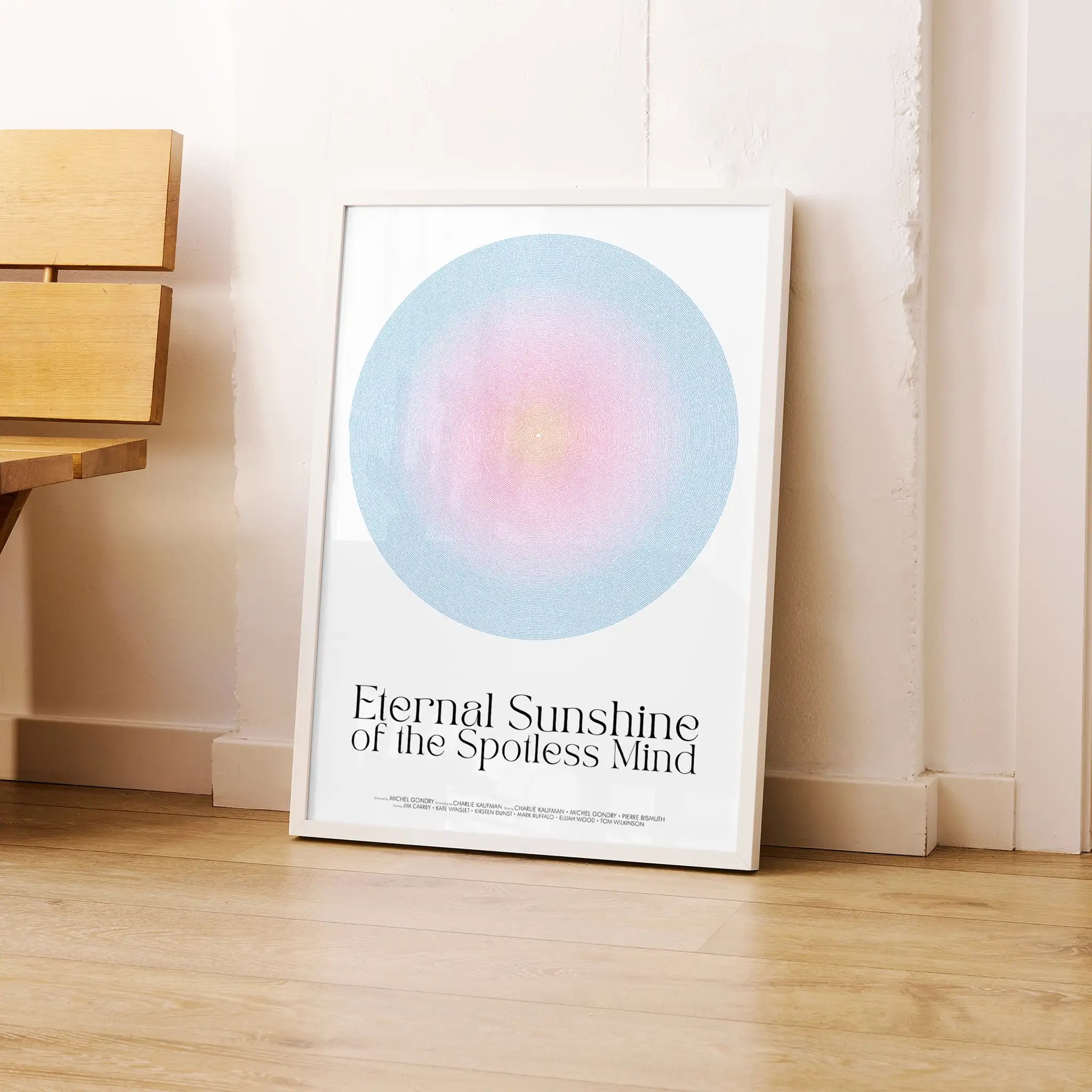 Framed Eternal Sunshine of the Spotless Mind movie poster artwork with a colorful circle and text on a wooden floor.