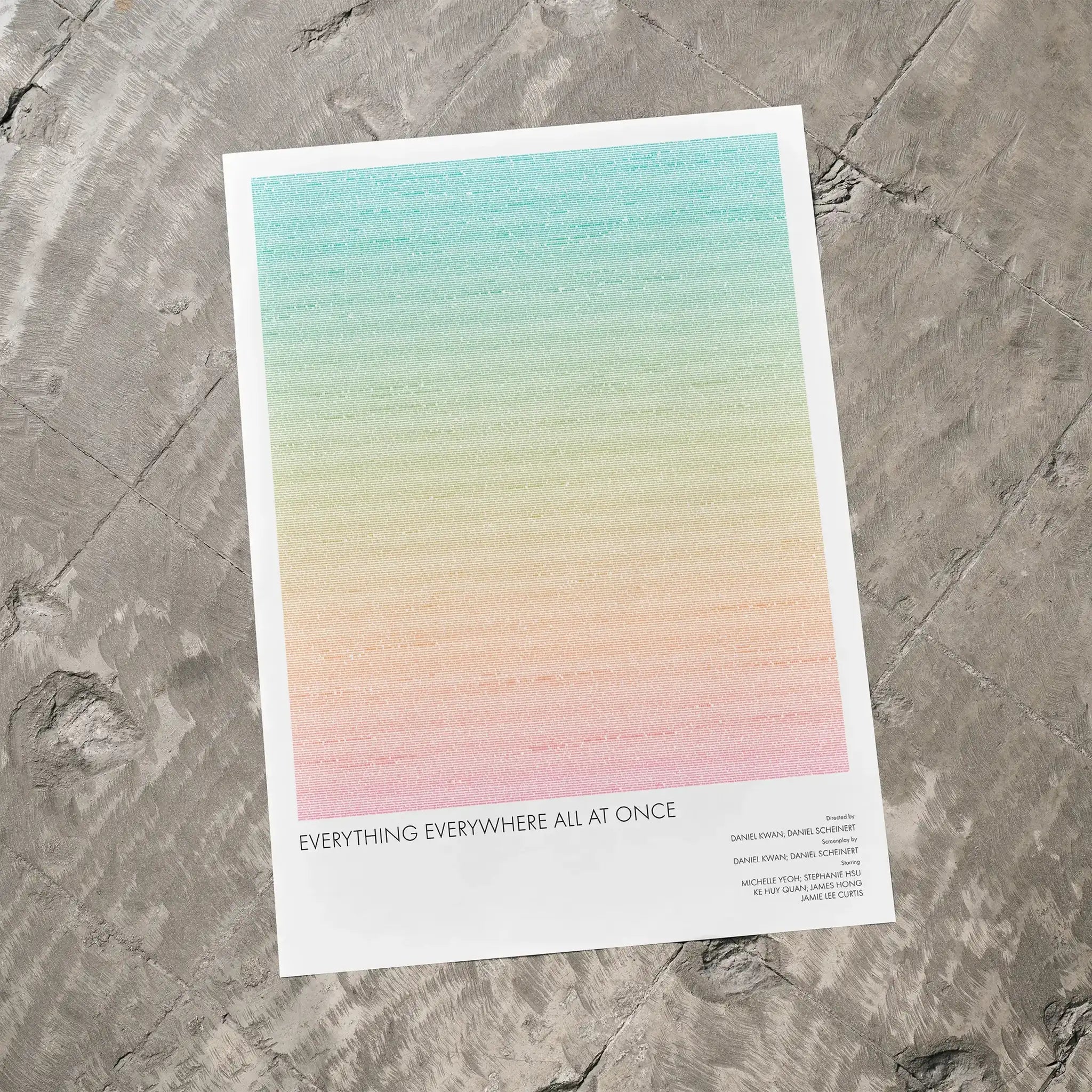 A Everything Everywhere All at Once movie script poster laid flat on a textured floor surface.