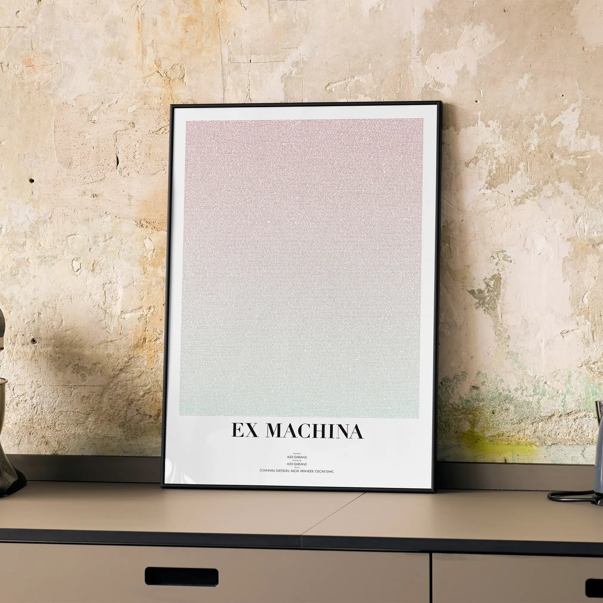 A framed Ex Machina movie script poster displayed on a cabinet in a minimalist interior.
