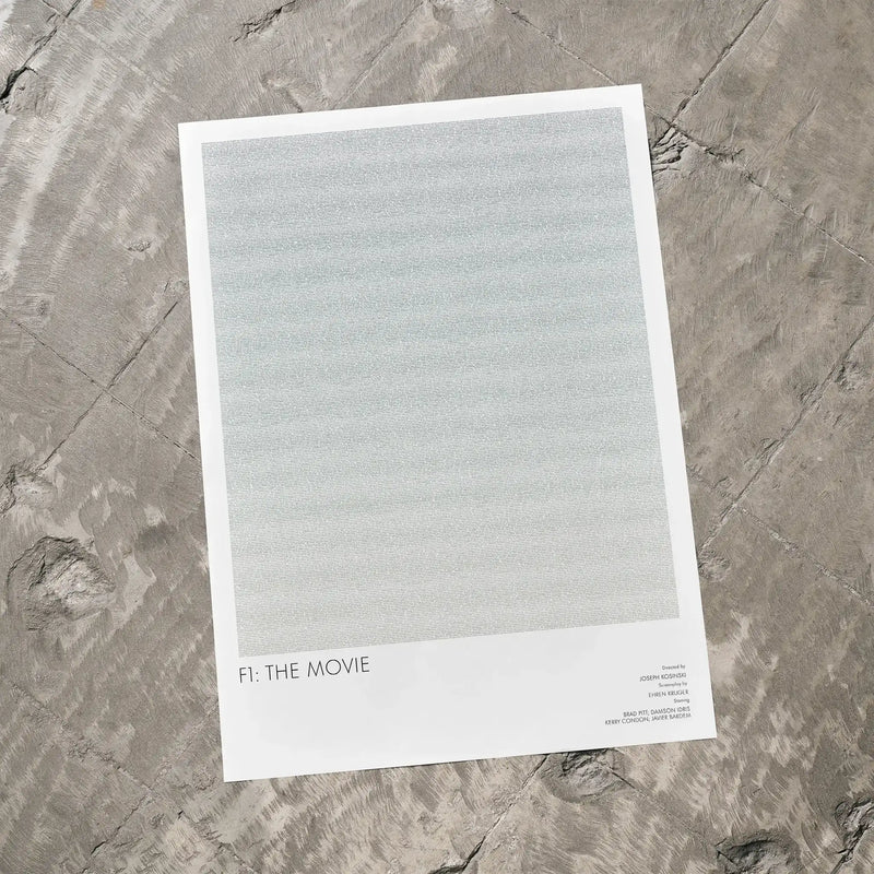 A F1: The Movie movie script poster laid flat on a textured floor surface.
