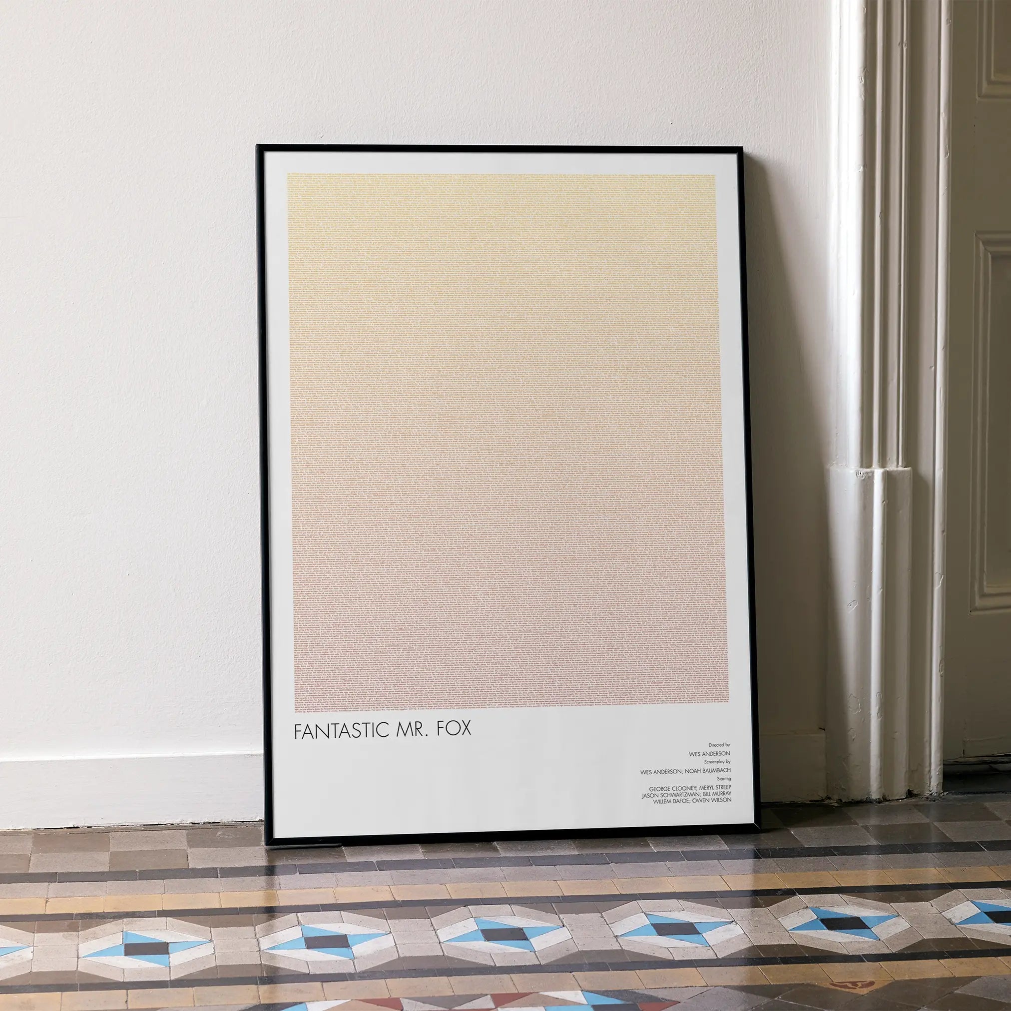A framed Fantastic Mr. Fox movie script poster leaning against a wall in a minimalist interior.