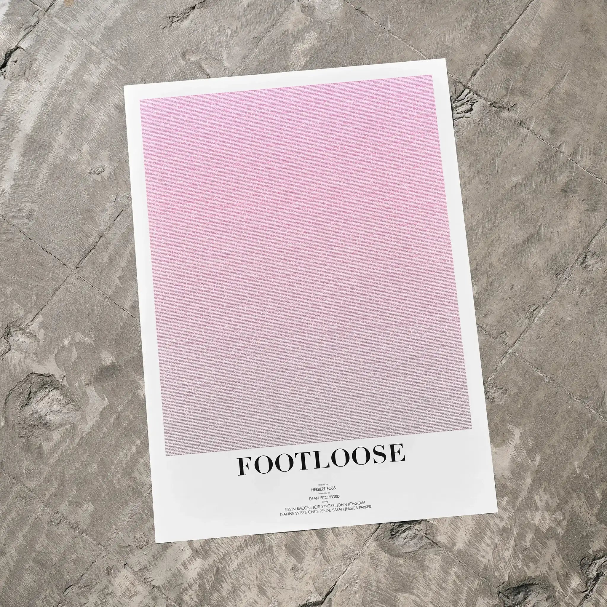 A Footloose movie script poster laid flat on a textured floor surface.