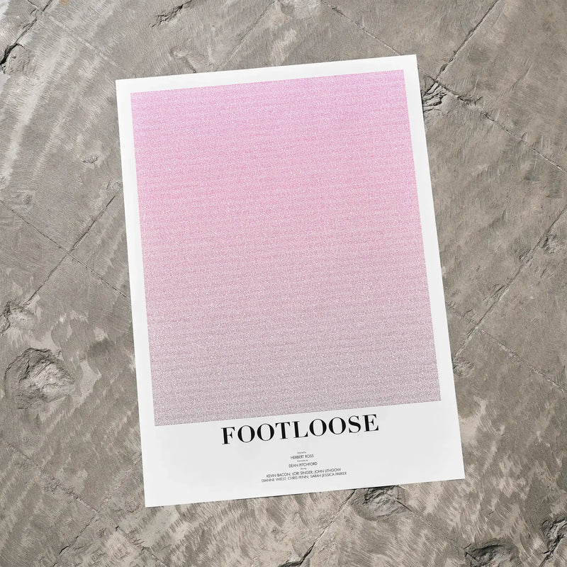 A Footloose movie script poster laid flat on a textured floor surface.