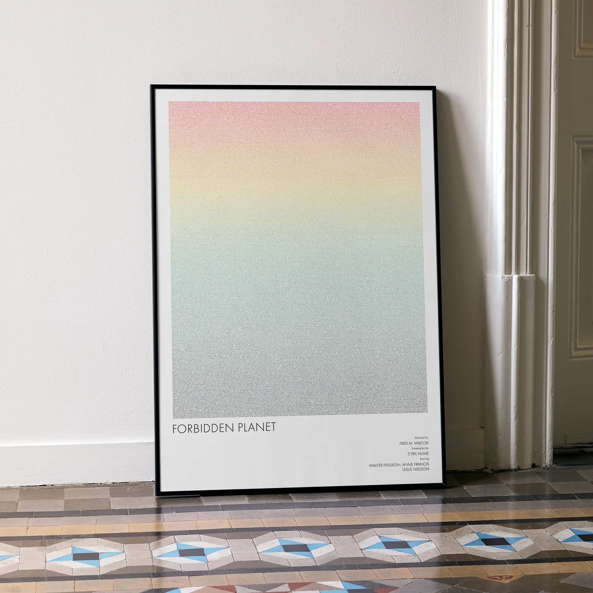 A framed Forbidden Planet movie script poster leaning against a wall in a minimalist interior.