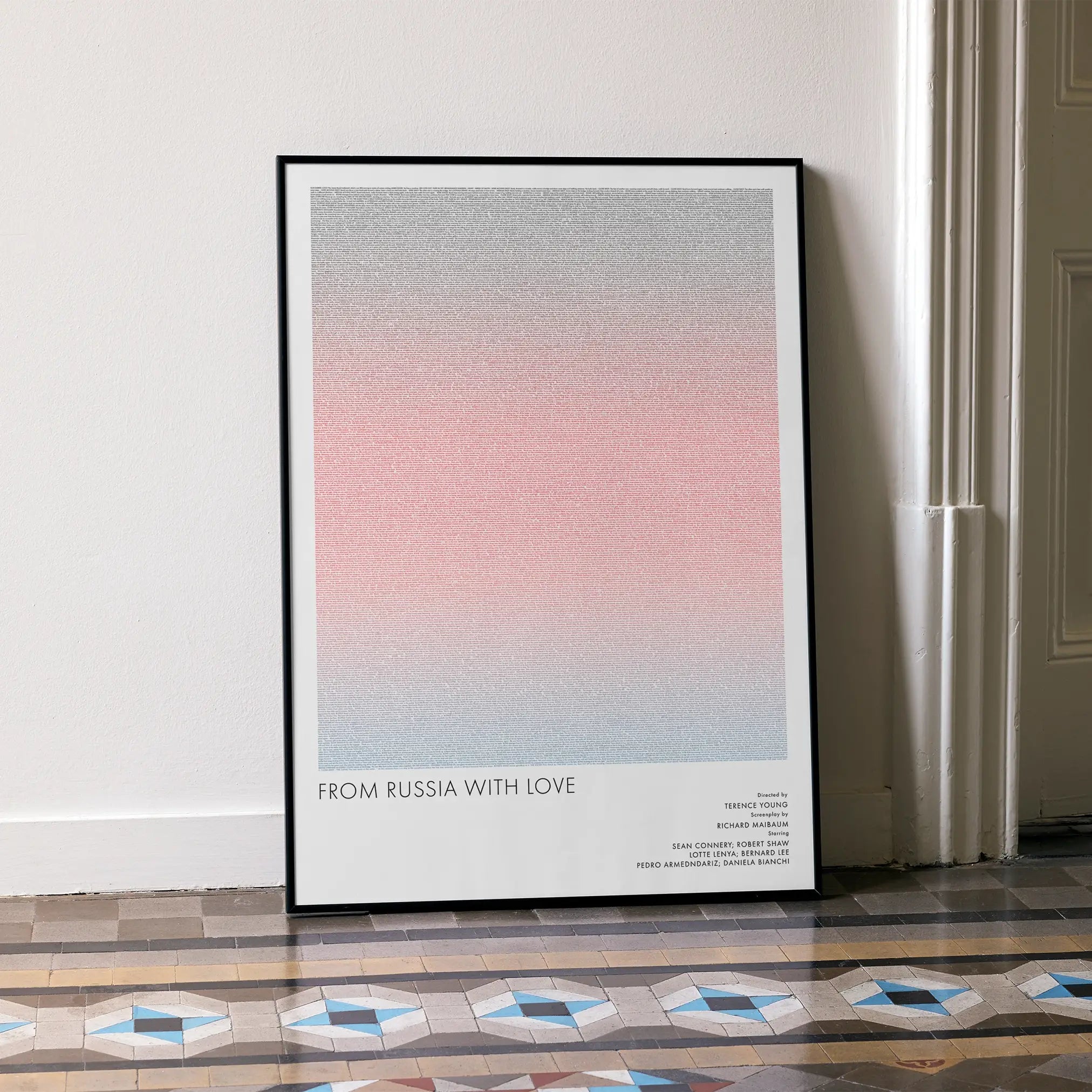 A framed From Russia with Love movie script poster leaning against a wall in a minimalist interior.