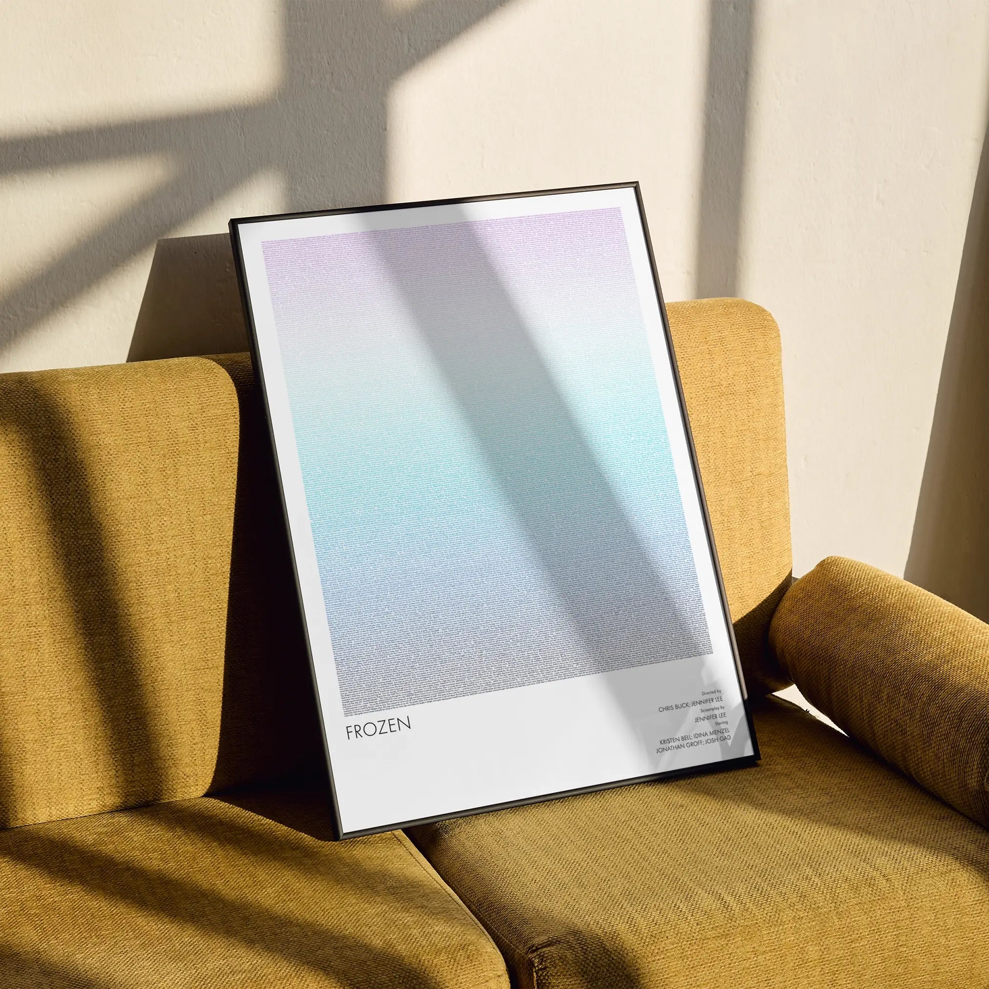 A framed Frozen movie script poster styled in a clean interior setting.