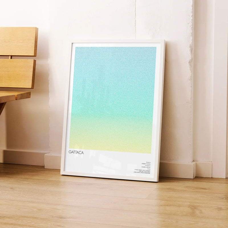 A framed Gattaca movie script poster leaning against a wall in a modern interior.