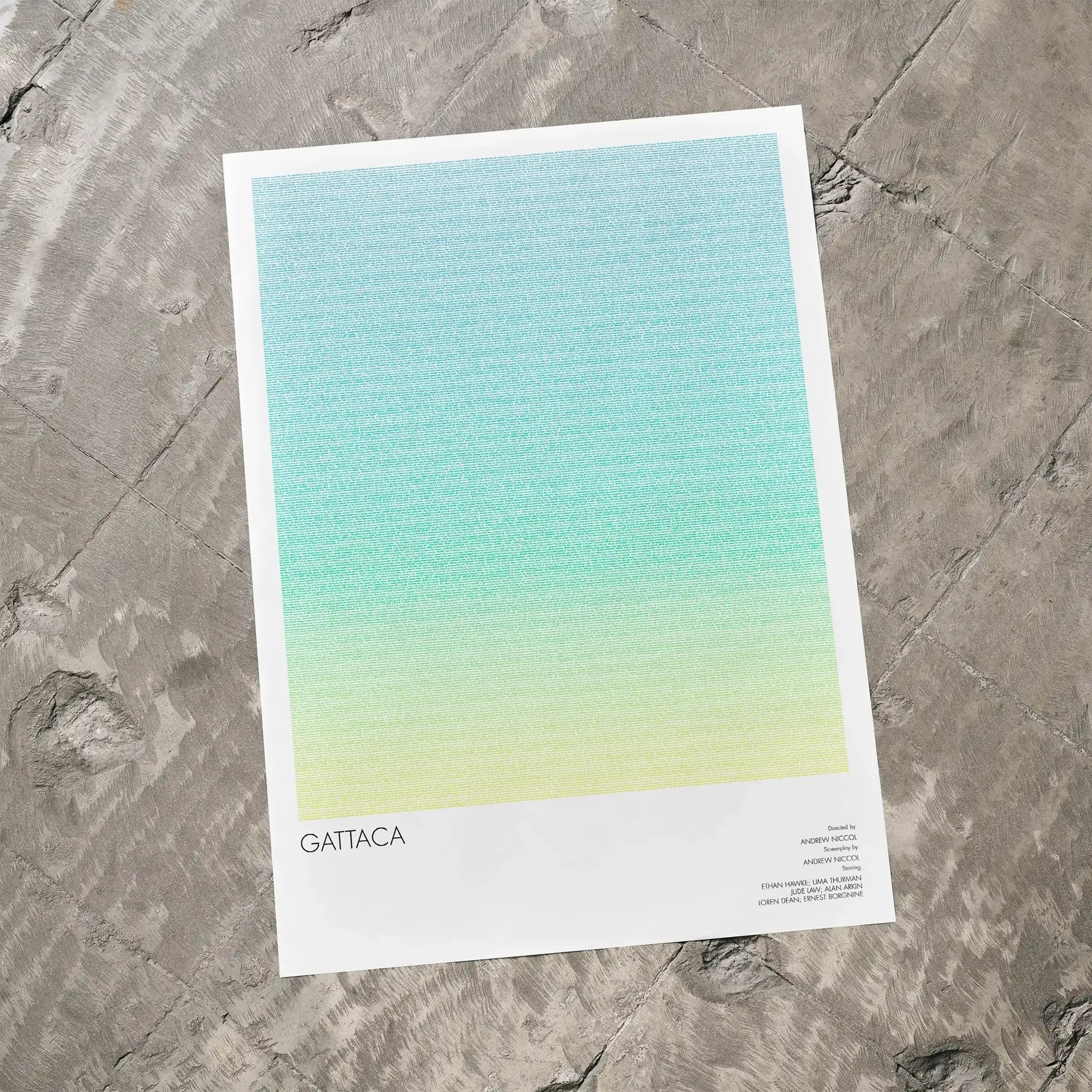 A Gattaca movie script poster laid flat on a textured floor surface.