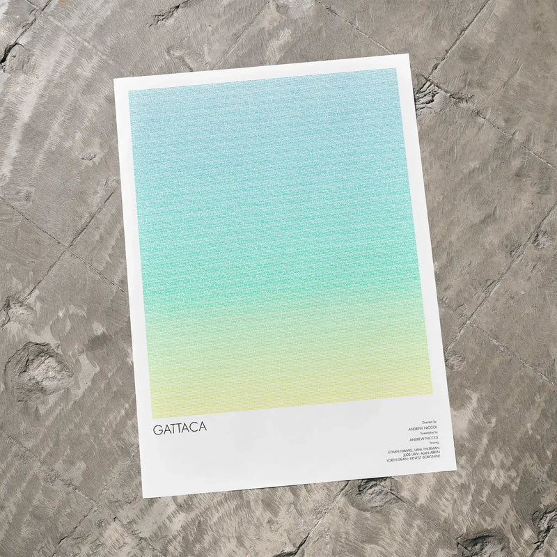 A Gattaca movie script poster laid flat on a textured floor surface.
