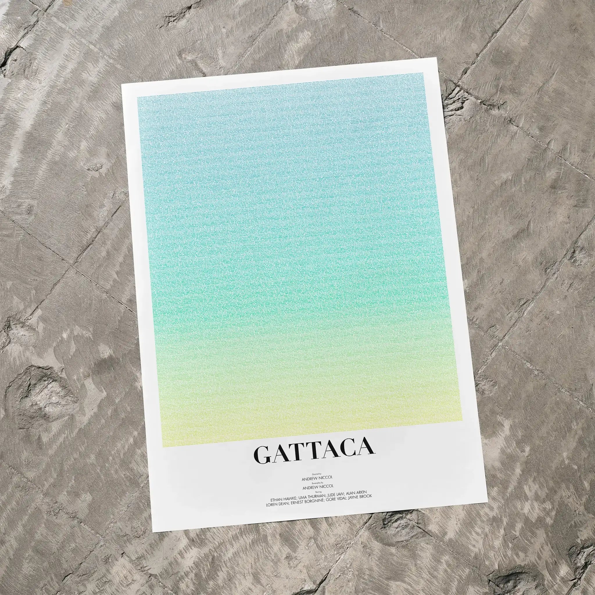 A Gattaca movie script poster laid flat on a textured floor surface.
