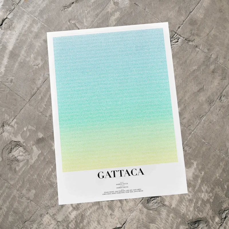A Gattaca movie script poster laid flat on a textured floor surface.
