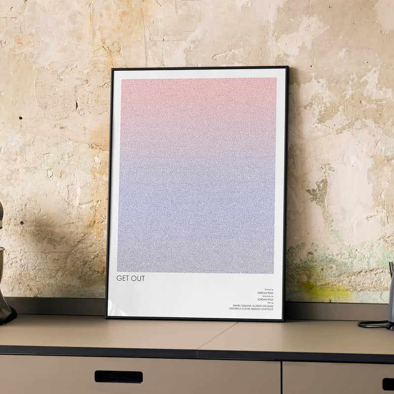 A framed Get Out movie script poster displayed on a cabinet in a minimalist interior.