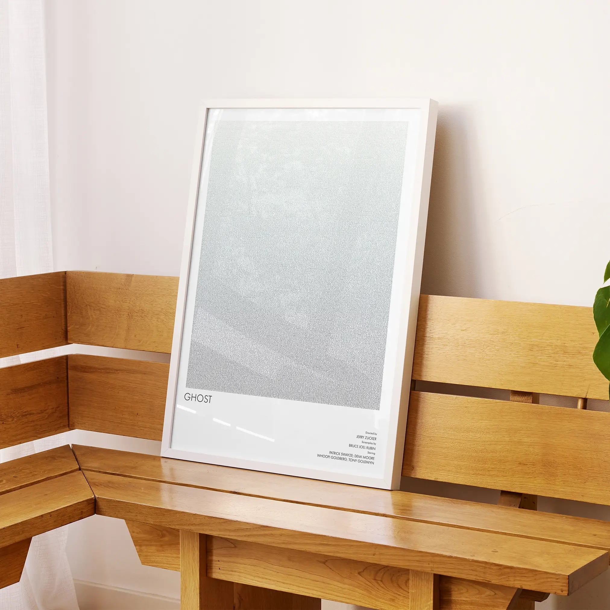 A framed Ghost movie script poster displayed on a sideboard in a contemporary space.