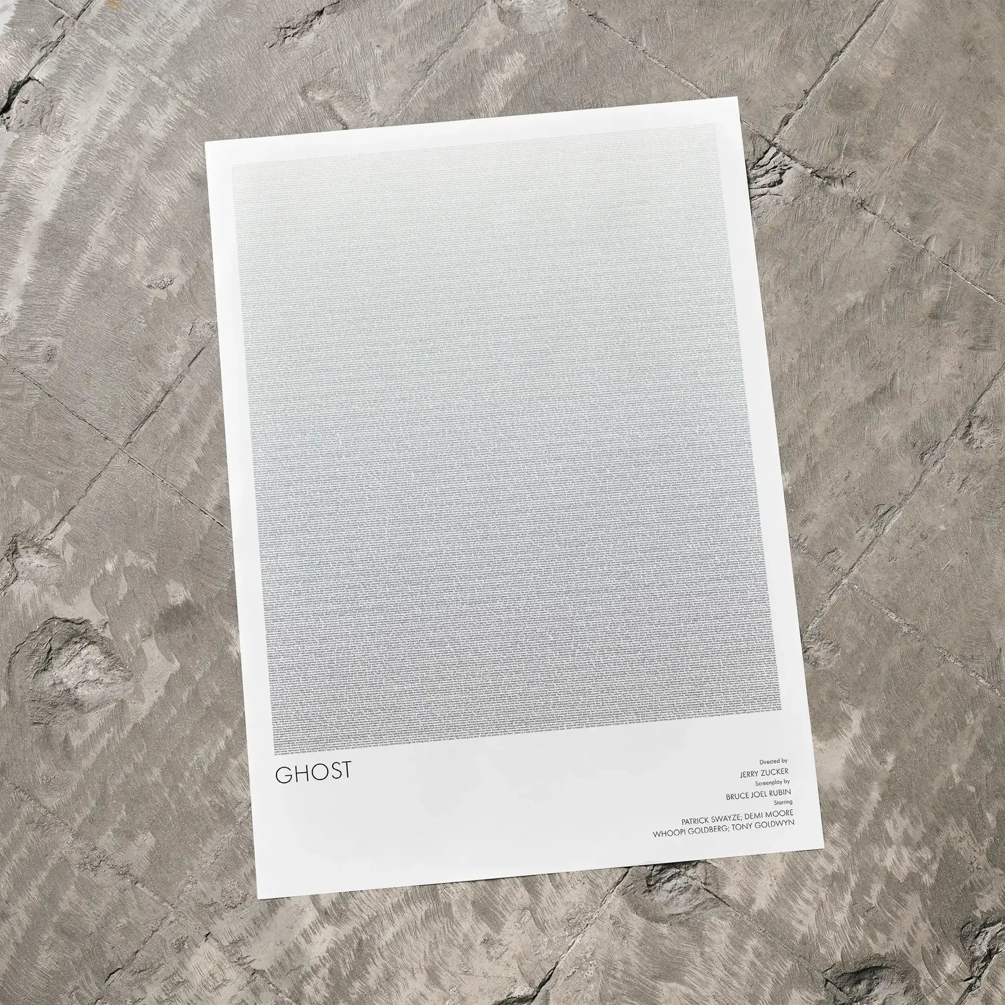 A Ghost movie script poster laid flat on a textured floor surface.