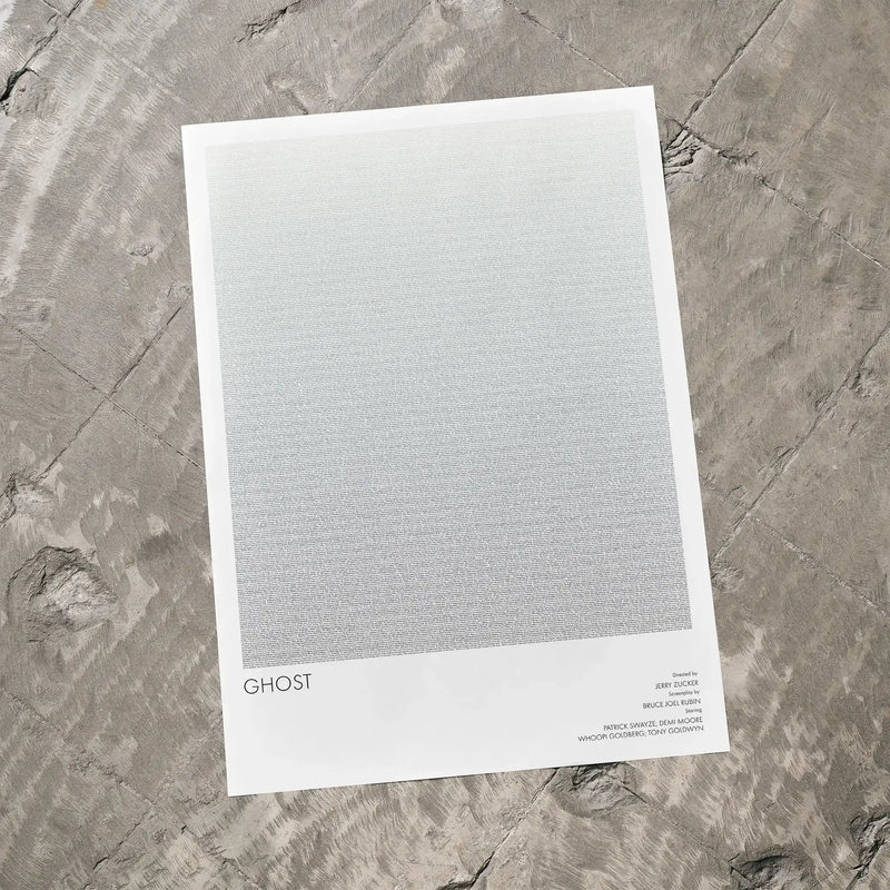A Ghost movie script poster laid flat on a textured floor surface.