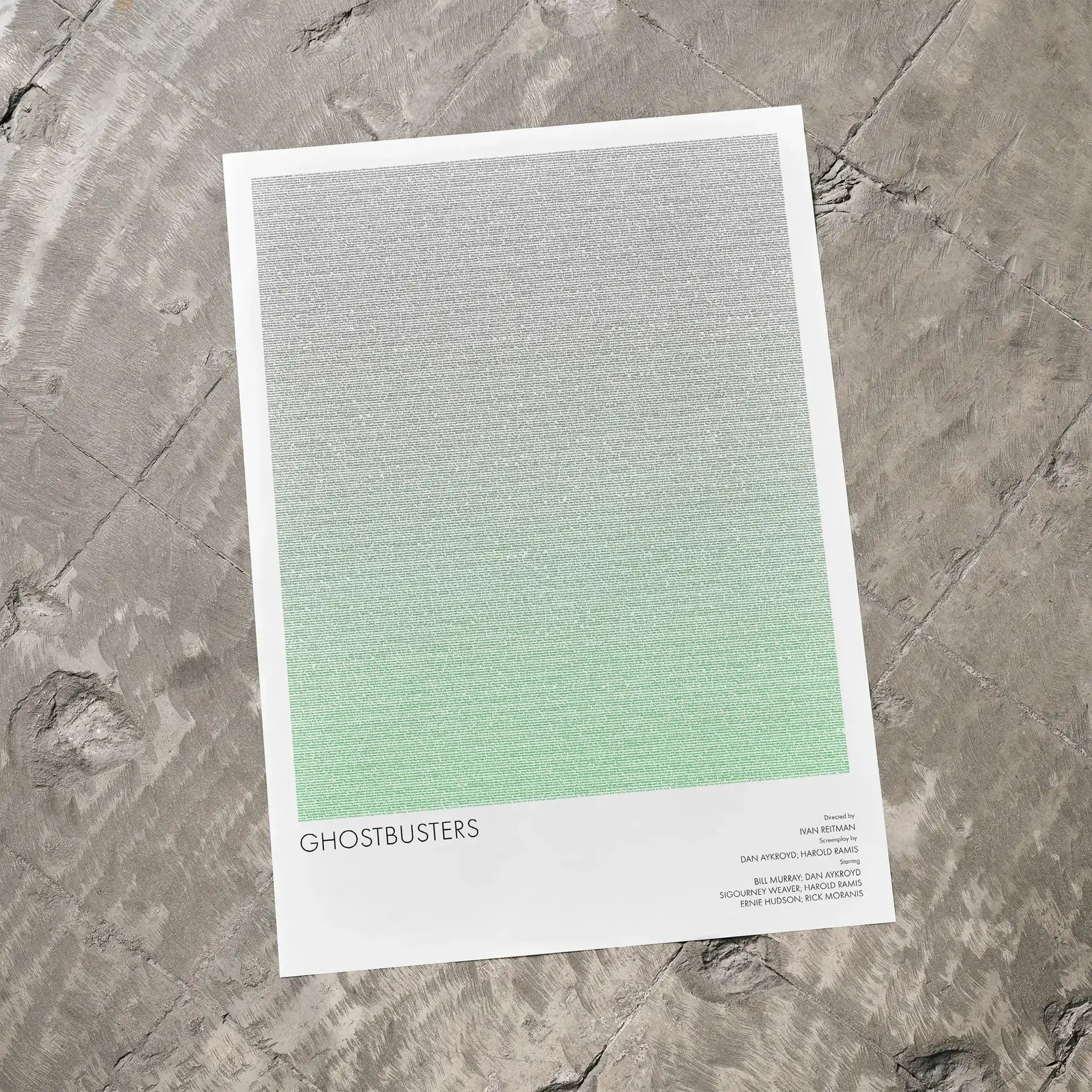 A Ghostbusters movie script poster laid flat on a textured floor surface.