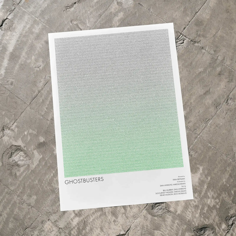 A Ghostbusters movie script poster laid flat on a textured floor surface.