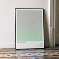 A framed Ghostbusters movie script poster leaning against a wall in a minimalist interior.