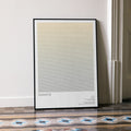 A framed Gladiator movie script poster leaning against a wall in a minimalist interior.