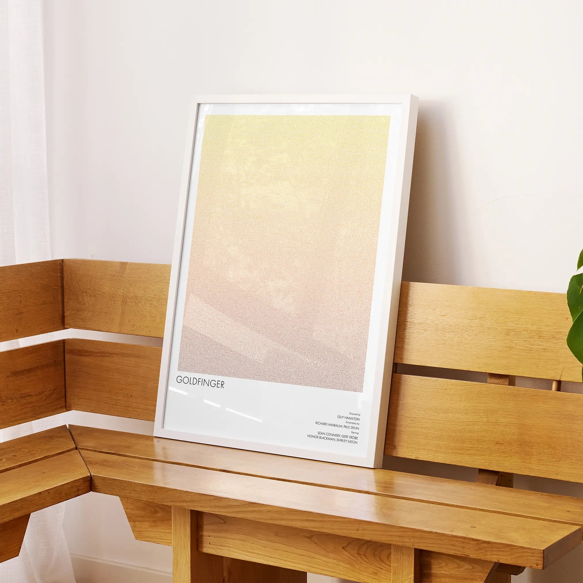 A framed Goldfinger movie script poster displayed on a sideboard in a contemporary space.