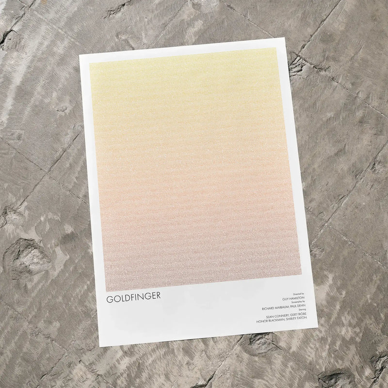 A Goldfinger movie script poster laid flat on a textured floor surface.