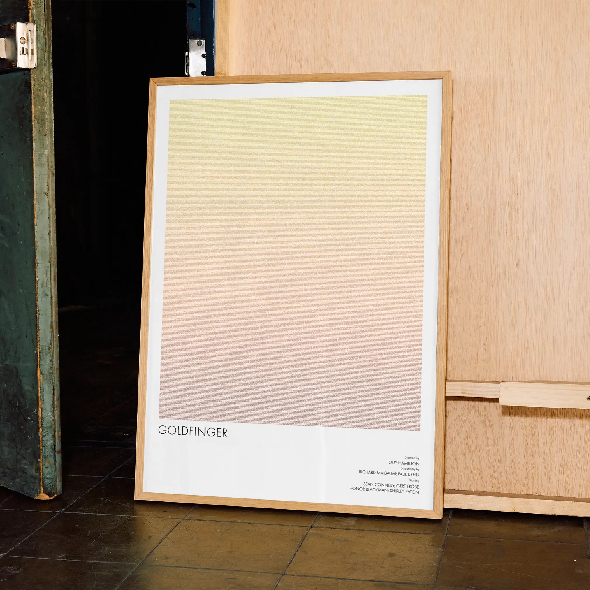 A framed Goldfinger movie script poster displayed in a contemporary interior setting.