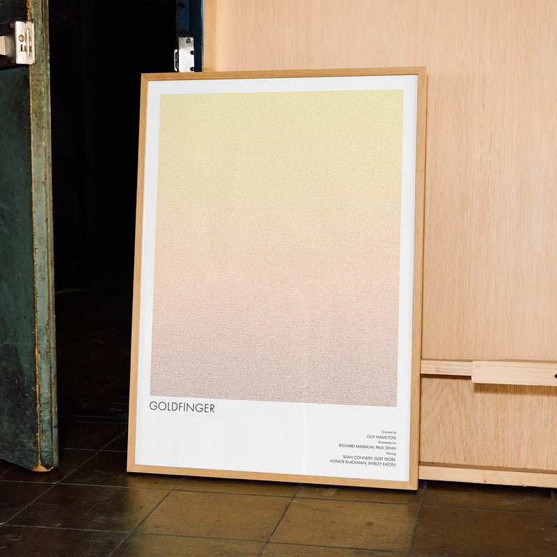 A framed Goldfinger movie script poster displayed in a contemporary interior setting.