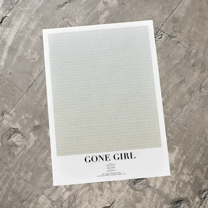 A Gone Girl movie script poster laid flat on a textured floor surface.