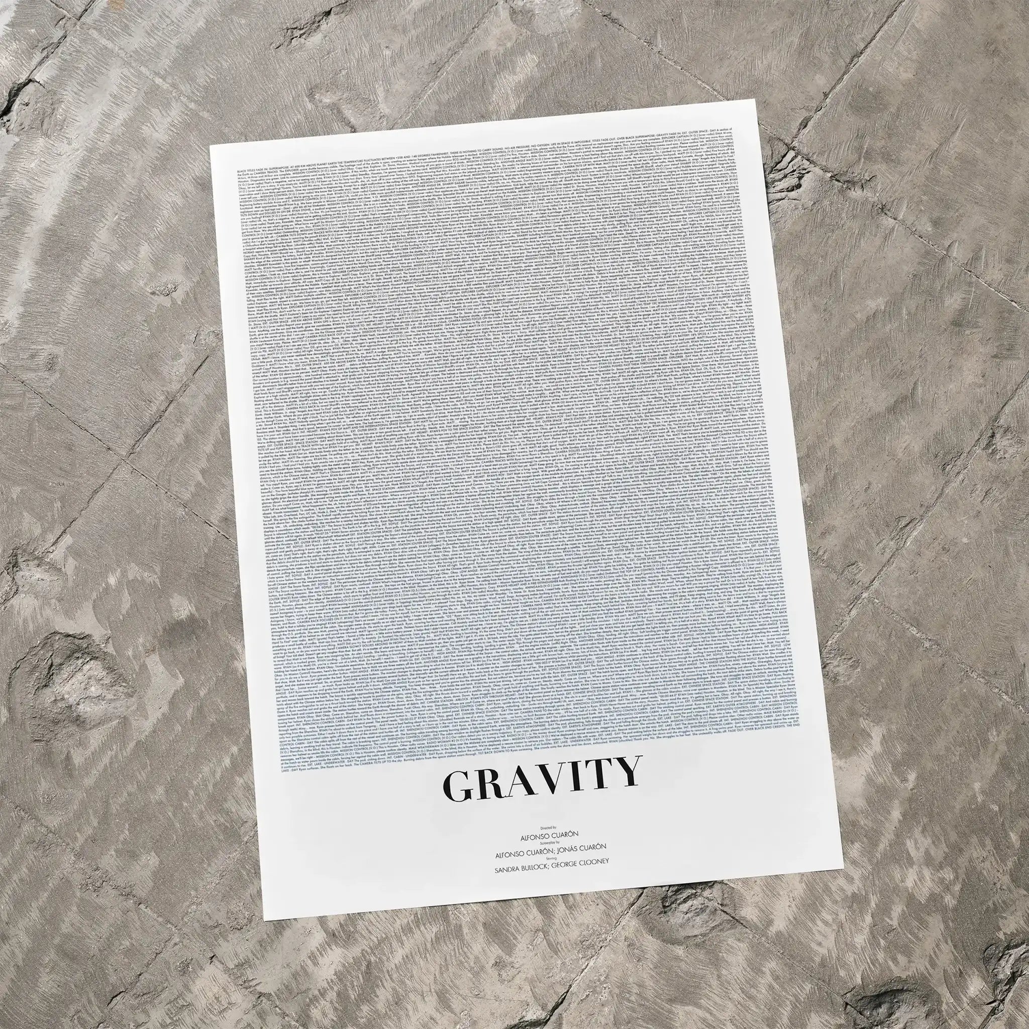 A Gravity movie script poster laid flat on a textured floor surface.