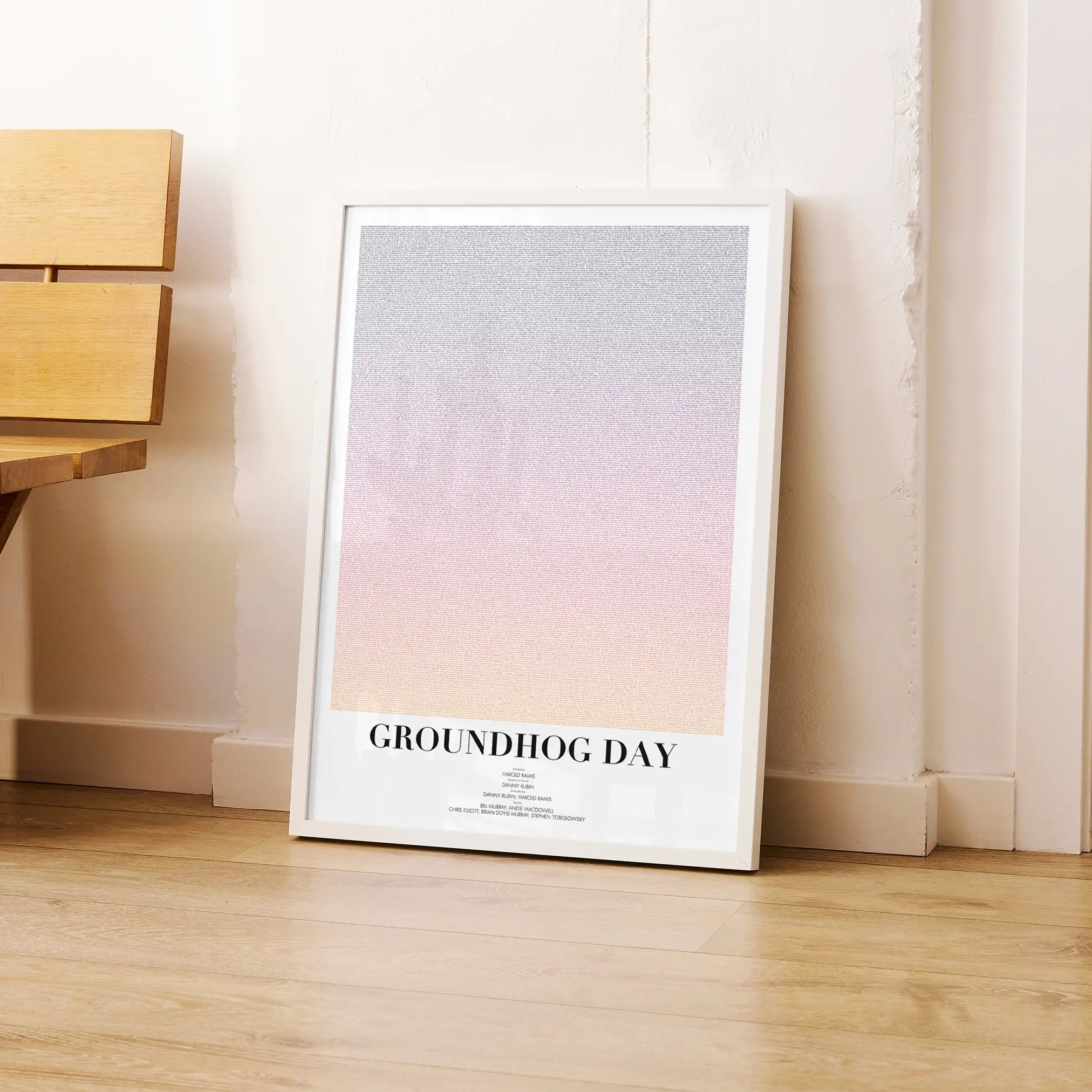 A framed Groundhog Day movie script poster leaning against a wall in a modern interior.