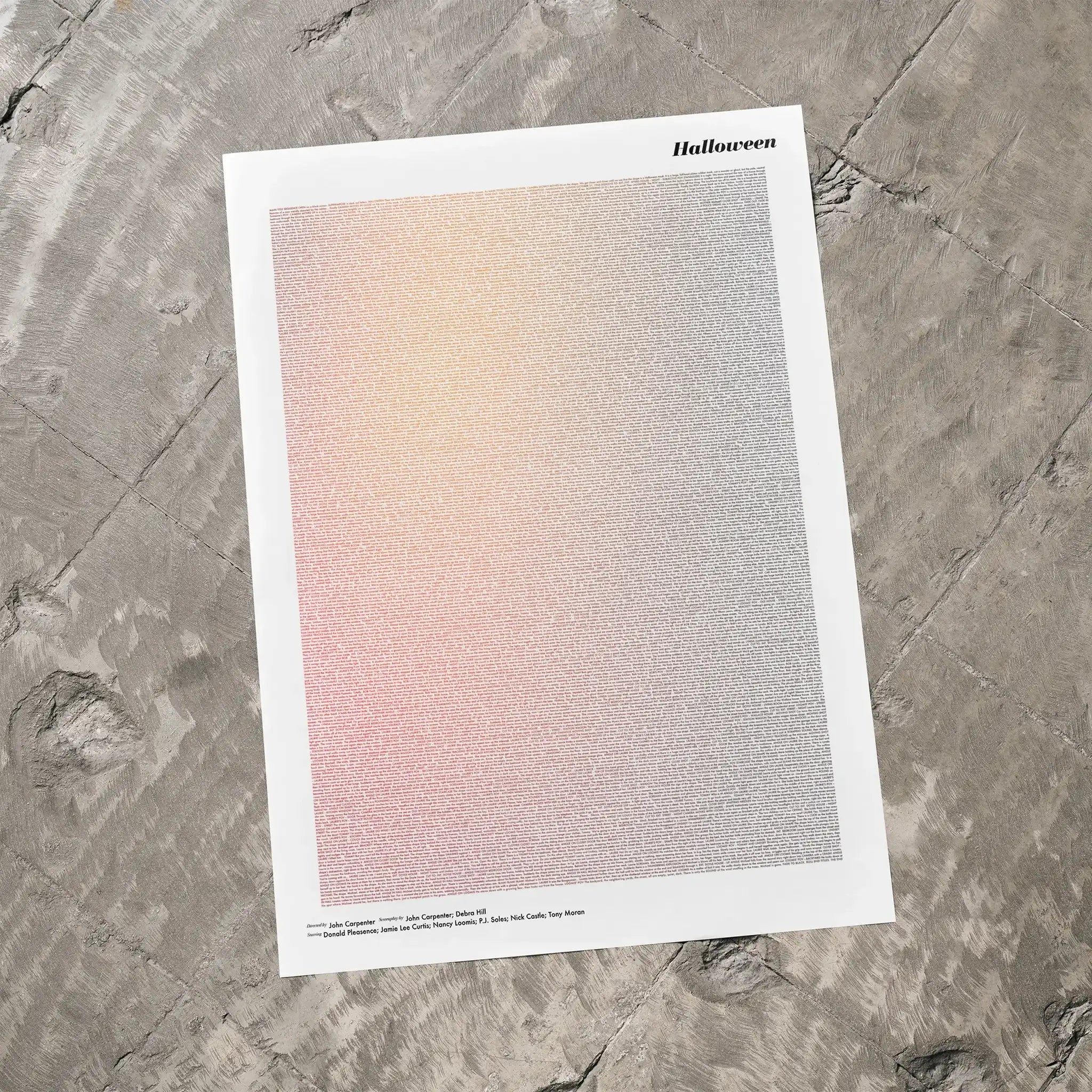A Halloween movie script poster laid flat on a textured floor surface.