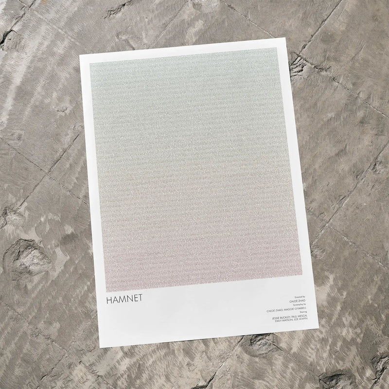 A Hamnet movie script poster laid flat on a textured floor surface.