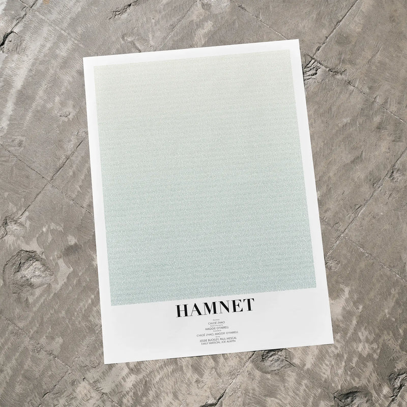 A Hamnet movie script poster laid flat on a textured floor surface.