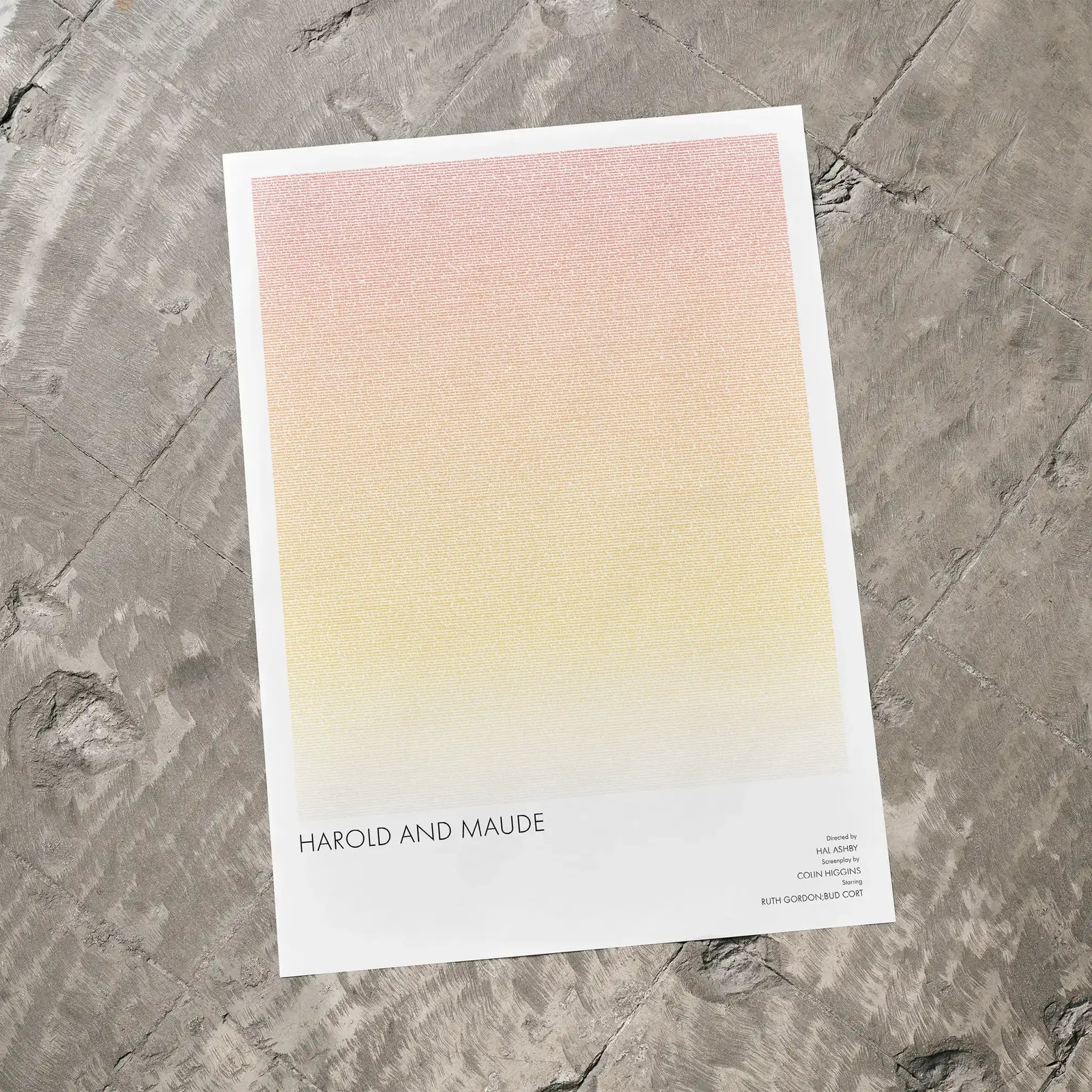 A Harold and Maude movie script poster laid flat on a textured floor surface.