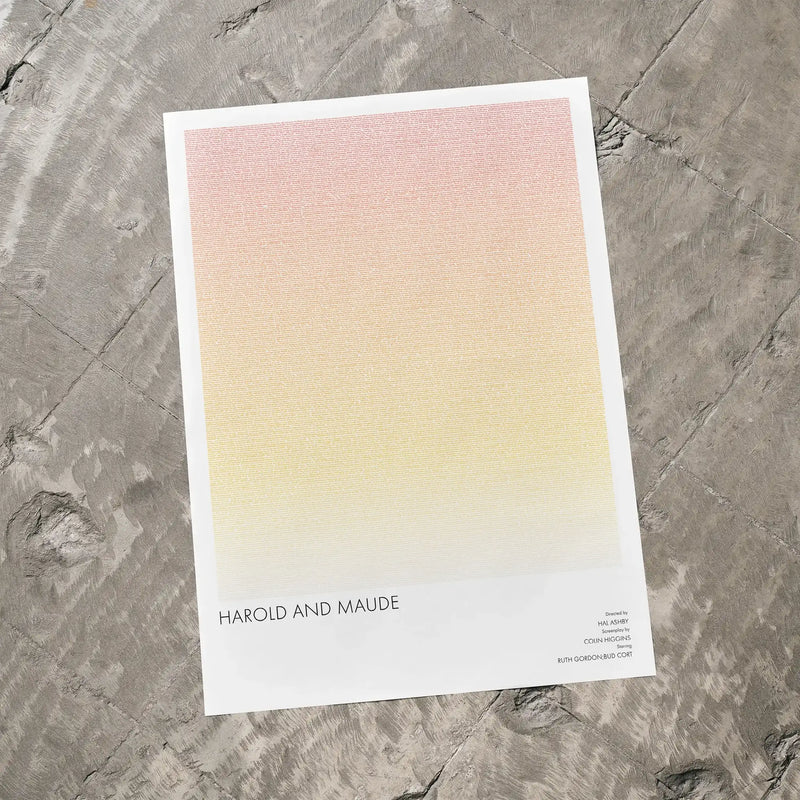 A Harold and Maude movie script poster laid flat on a textured floor surface.