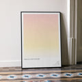 A framed Harold and Maude movie script poster leaning against a wall in a minimalist interior.
