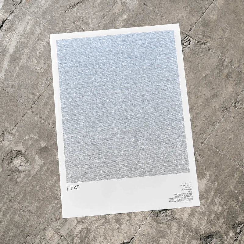 A Heat movie script poster laid flat on a textured floor surface.