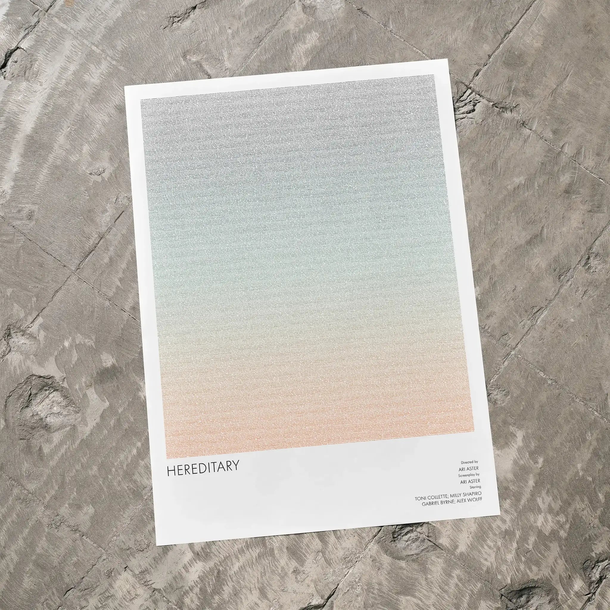 A Hereditary movie script poster laid flat on a textured floor surface.