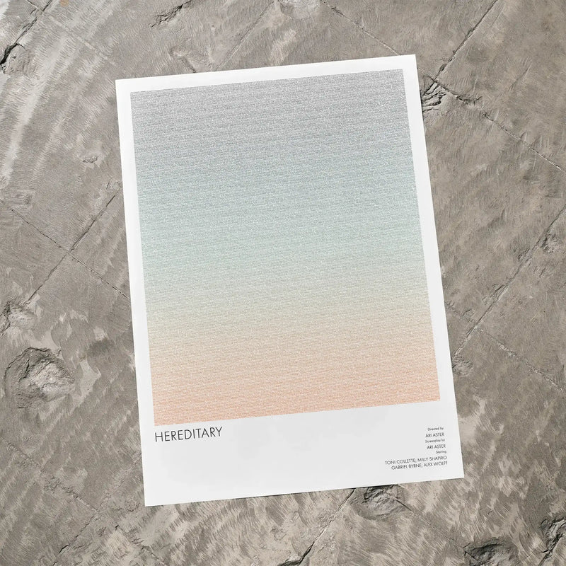 A Hereditary movie script poster laid flat on a textured floor surface.