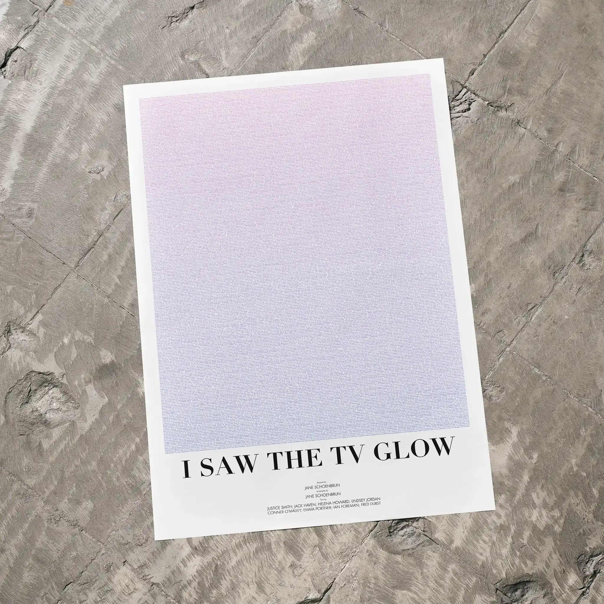 A I Saw the TV Glow movie script poster laid flat on a textured floor surface.
