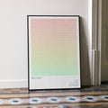 A framed Idiocracy movie script poster leaning against a wall in a minimalist interior.