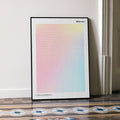 A framed Idiocracy movie script poster leaning against a wall in a minimalist interior.