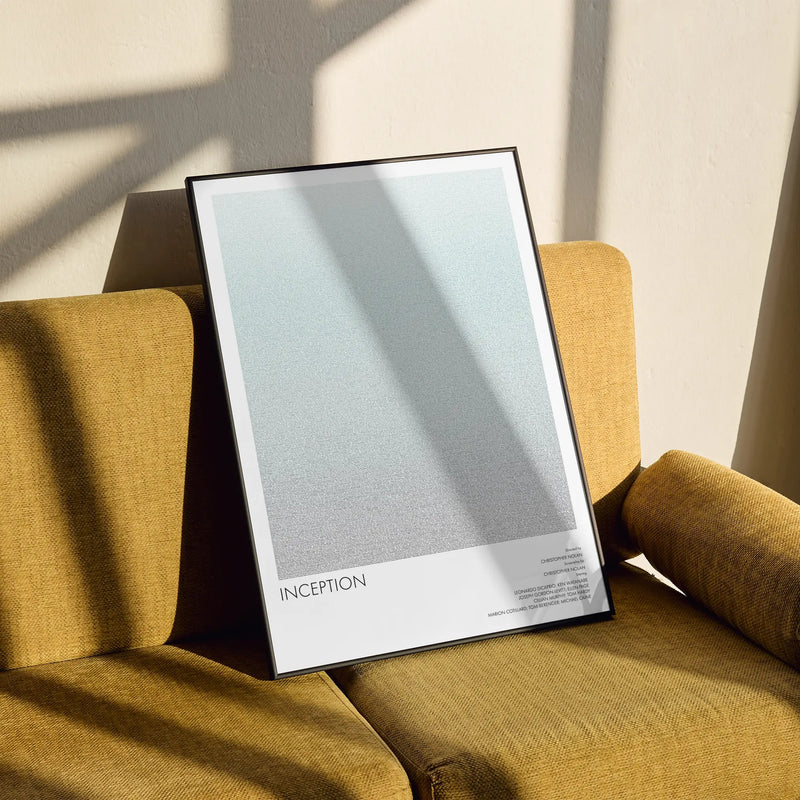 Framed artwork titled 'Inception' on a mustard yellow armchair