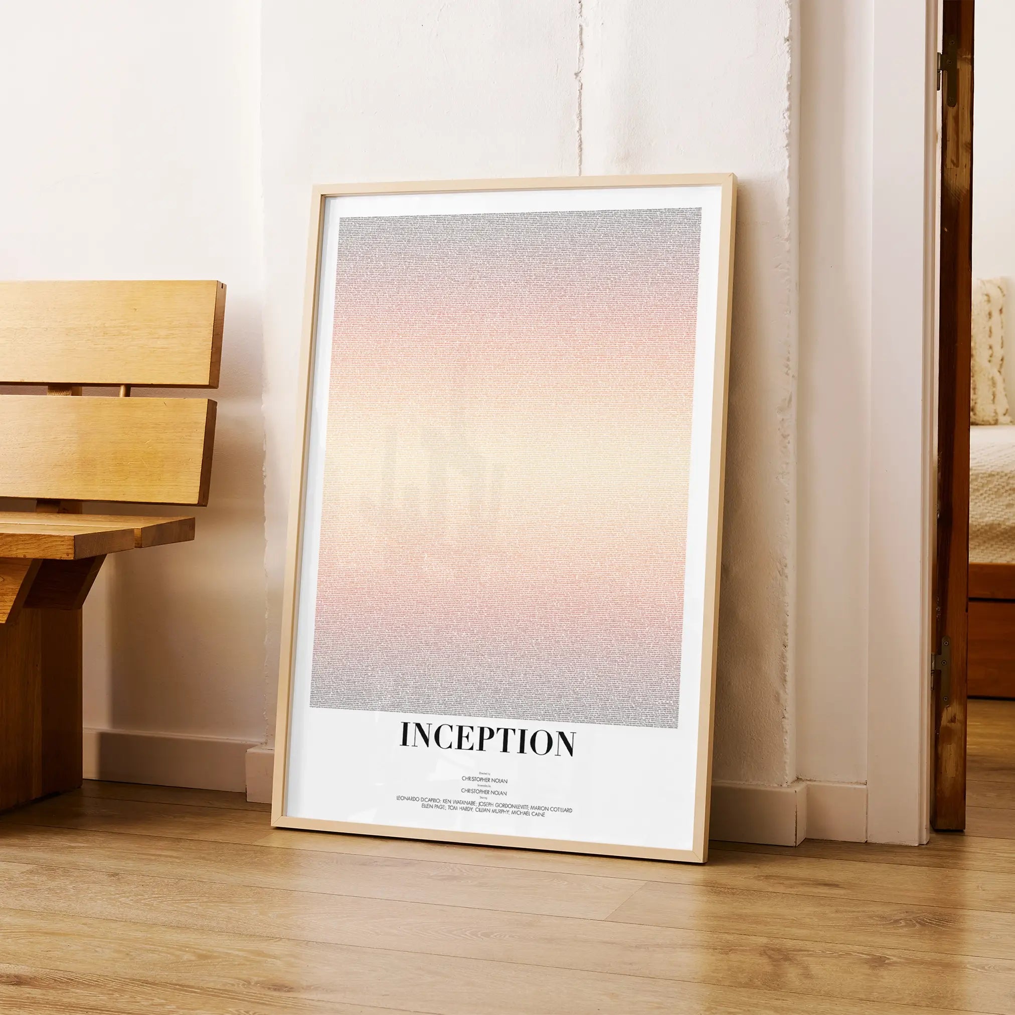 Framed poster titled 'Inception' leaning against a wall in a room with wooden furniture.