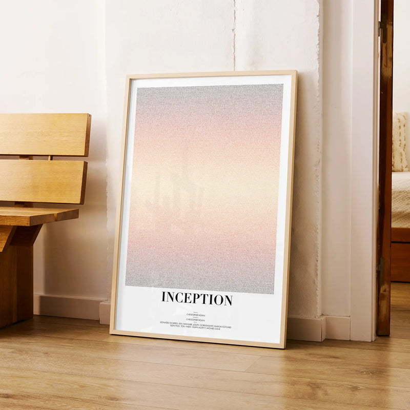Framed poster titled 'Inception' leaning against a wall in a room with wooden furniture.